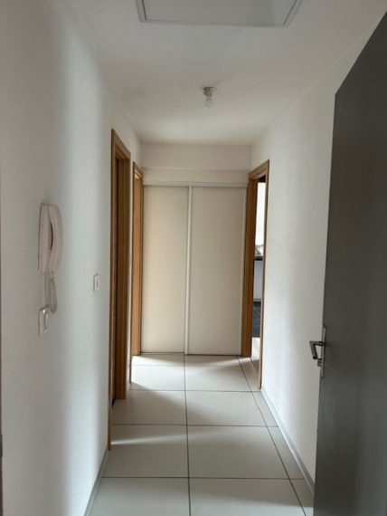 Le couloir de cet appartement T3 à Guebwiller dispose d’un placard de rangement et donne accès à la grande pièce de vie, aux deux chambres et à la salle de bain avec wc.